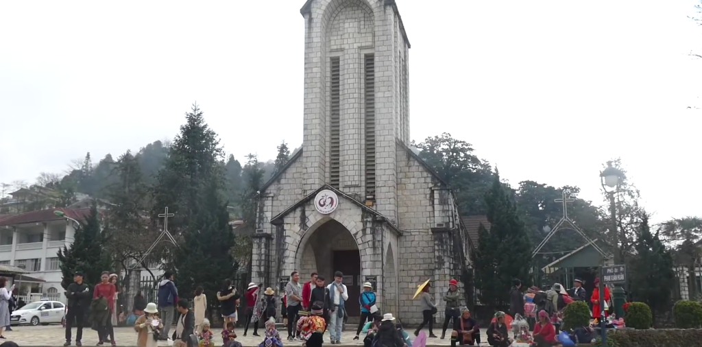 nhà thờ đá nhìn từ xa có những khách du lịch đang tham quan chụp ảnh