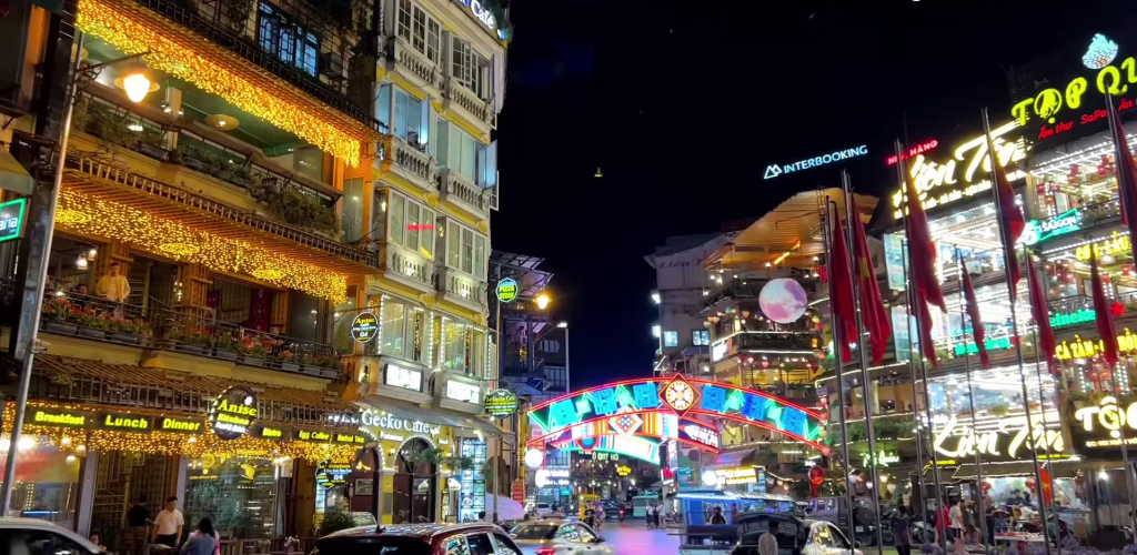 cảnh nhìn bên ngoài vào ban đêm của chợ SaPa không khí nhộn nhịp xe cô và người qua lại. Chợ SaPa thuộc các địa điểm tham quan tại SaPa